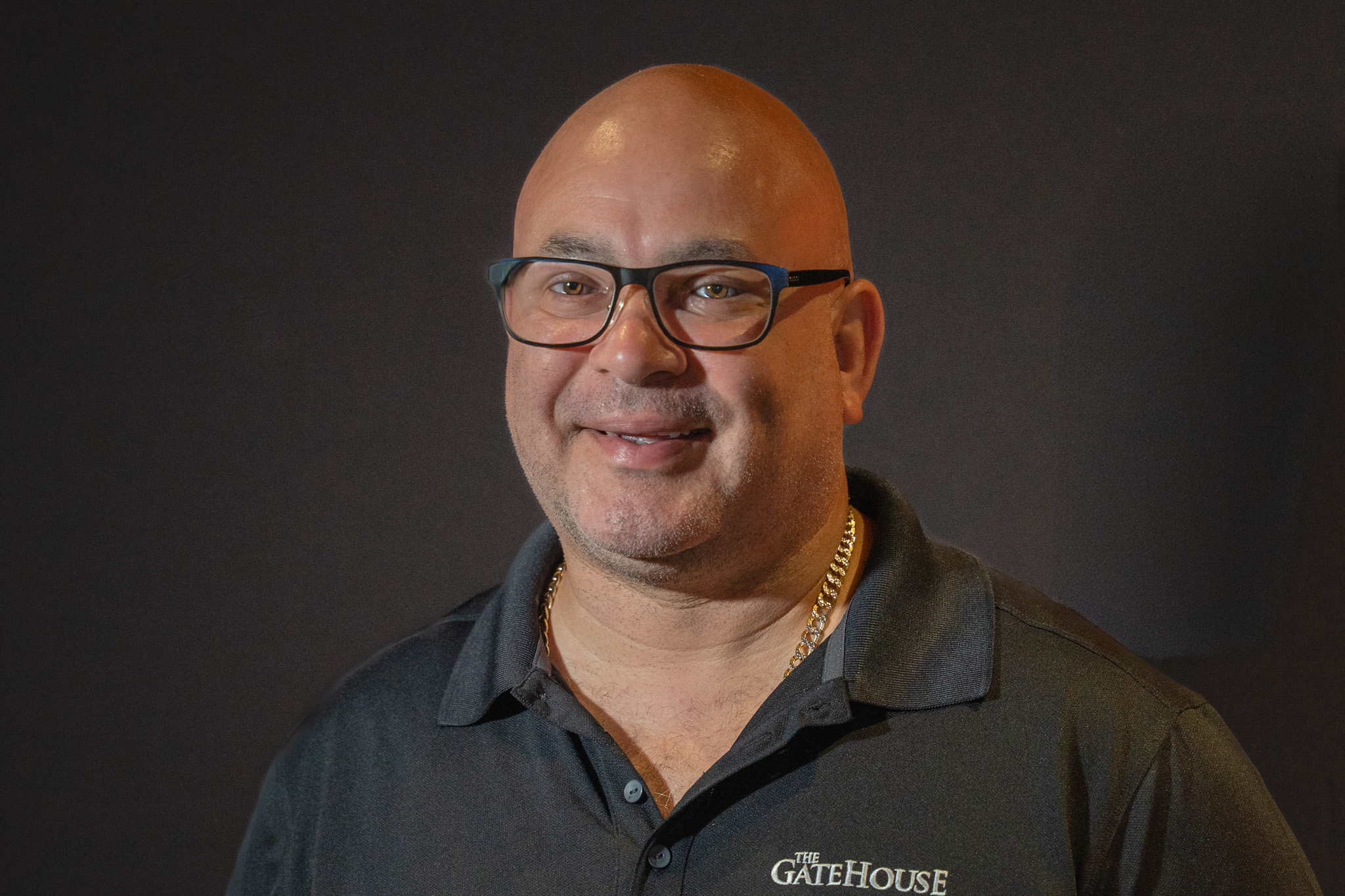 Anthony Valentin wearing glasses and a dark polo shirt